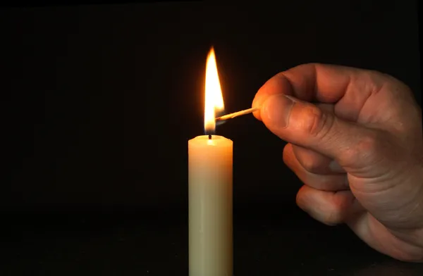 Hand Lighting Candle Stock Photo