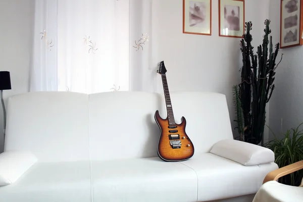 Guitarra en el sofá — Foto de Stock