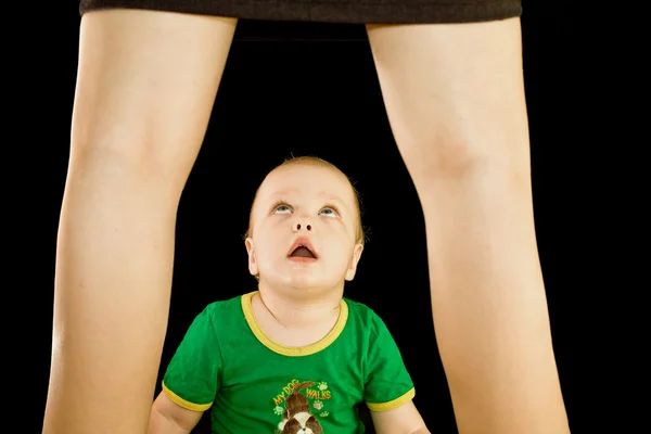 Rapaz olha debaixo de uma saia para a mãe — Fotografia de Stock