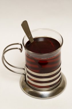 Glass of black tea with steel glass hold clipart