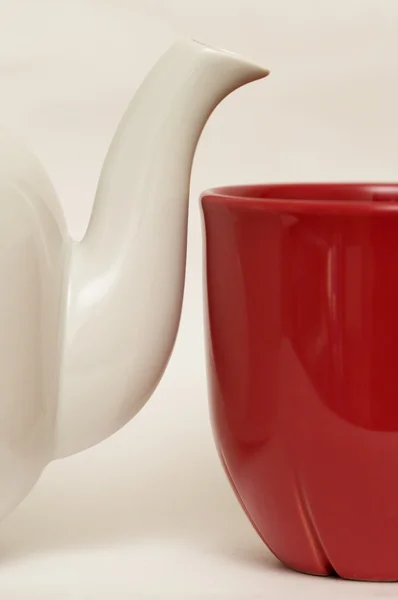 Panela de chá de faiança vitrificada branca e copo vermelho — Fotografia de Stock