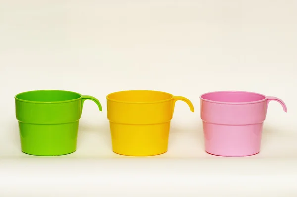 Три цветные пластиковые чашки — стоковое фото