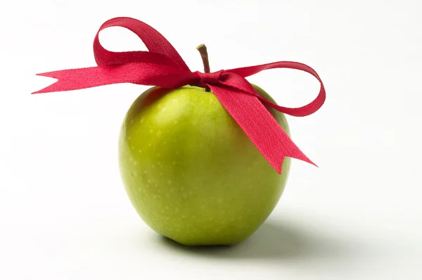 Зелене яблуко і червона стрічка лук — стокове фото