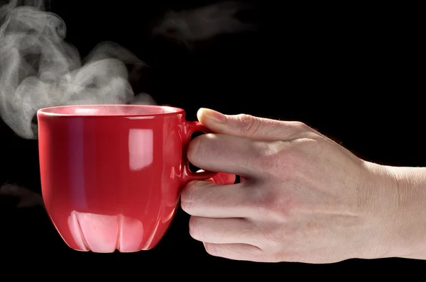 Kleine rote Teetasse in der Hand einer Frau — Stockfoto