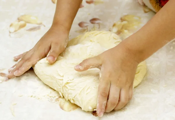Hands of the child knead the dough for a — Stock Photo, Image