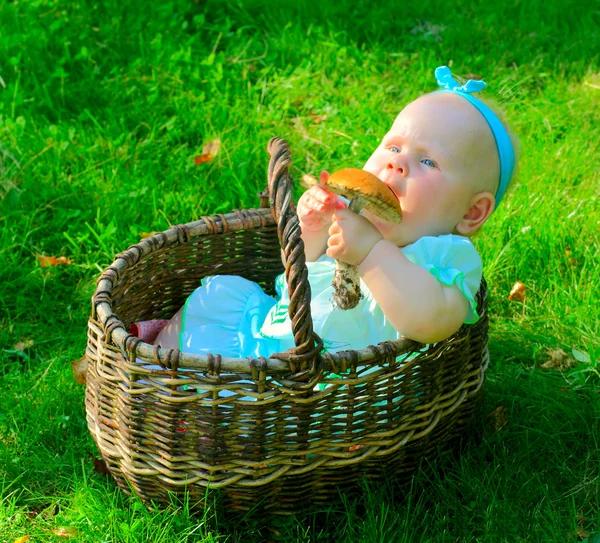 Meisje van de baby in mand eten paddestoel — Stockfoto