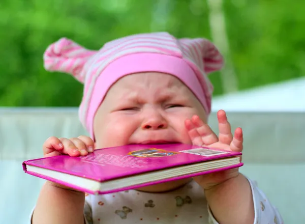 Baby äter bok Royaltyfria Stockfoton
