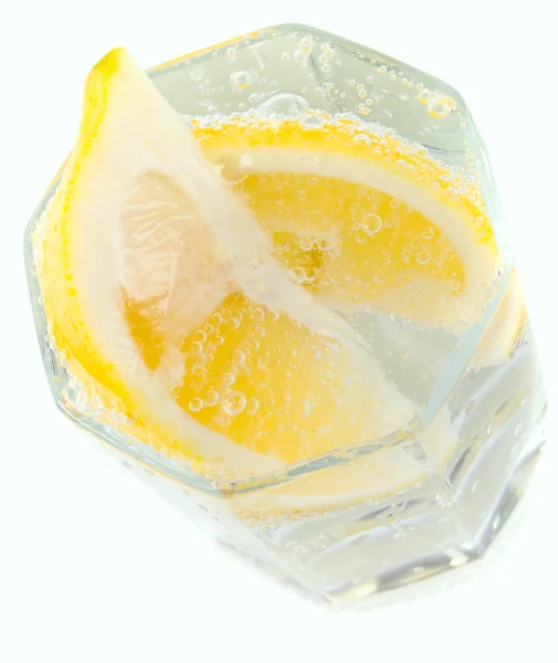 Glas met soda water en citroen segmenten — Stockfoto