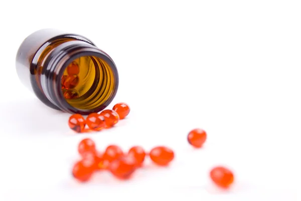 Garrafa com comprimidos vermelhos — Fotografia de Stock