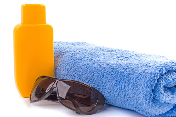 Полотенце, солнцезащитные очки и лосьон — стоковое фото