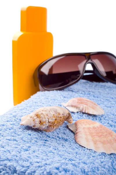 Handdoek, schelpen, zonnebril en lotion — Stockfoto