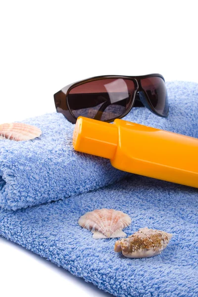 Håndklæde, skaller, solbriller og lotion - Stock-foto
