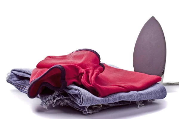 Iron and pile of clothes — Stock Photo, Image