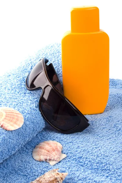 Toalha, óculos de sol e loção — Fotografia de Stock