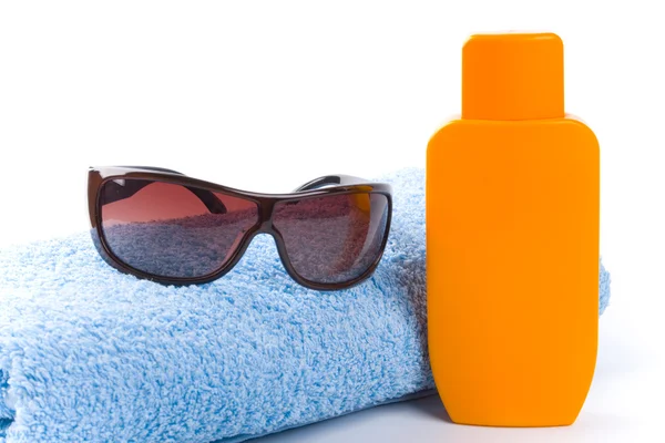 Toalha, óculos de sol e loção — Fotografia de Stock