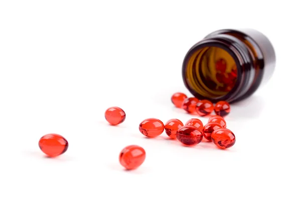 Garrafa com comprimidos vermelhos — Fotografia de Stock