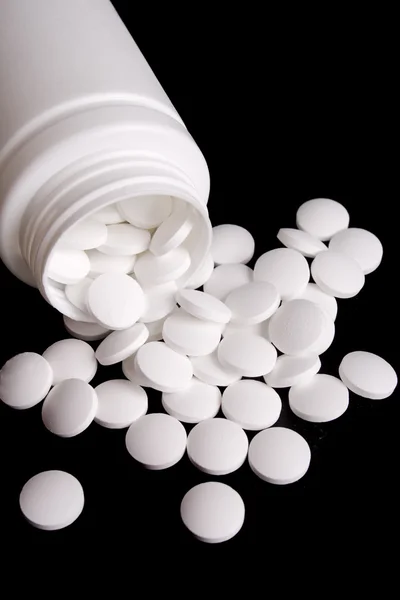 Garrafa com comprimidos brancos — Fotografia de Stock