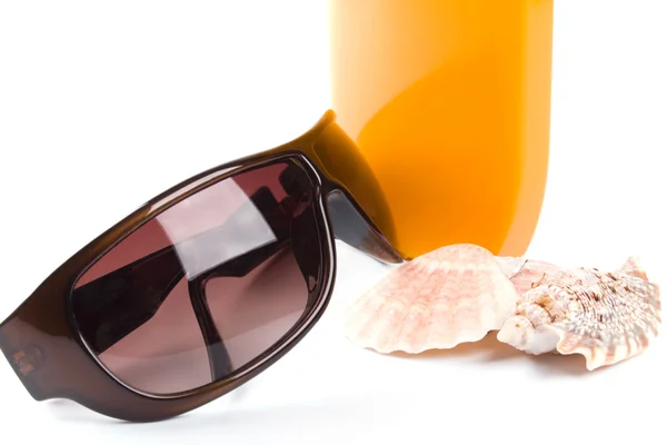 Solbriller, skaller og lotion - Stock-foto