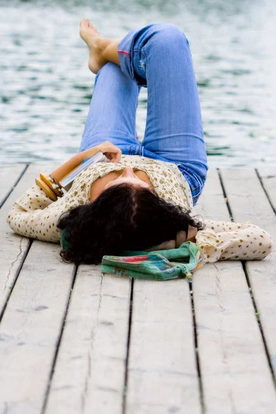 Vrouw liggen in de buurt van de rivier — Stockfoto