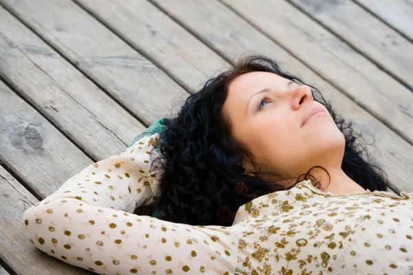 Žena leží na dřevěné podlaze — Stock fotografie