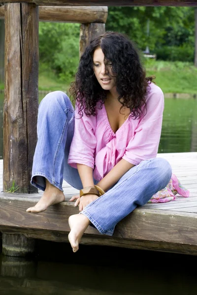 Kobieta siedzi w pobliżu wody — Zdjęcie stockowe