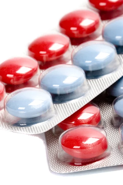 Červené a modré pilulky v plastový blistr — Stock fotografie