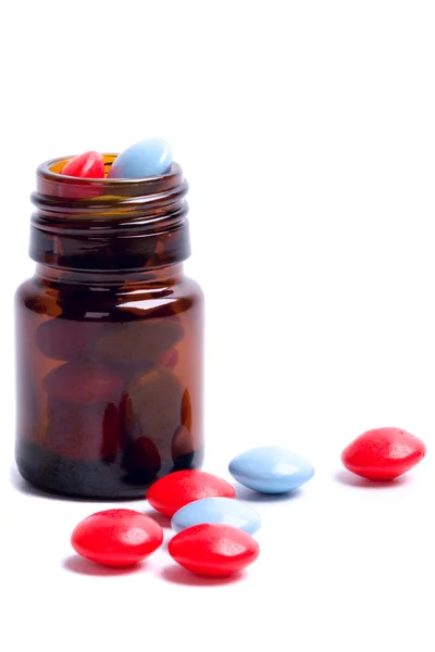 Flacon en verre avec des pilules rouges et bleues — Photo