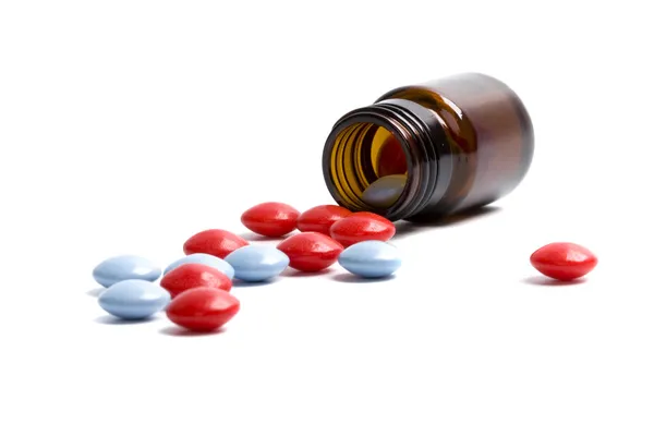 Glass bottle with red and blue pills Stock Photo