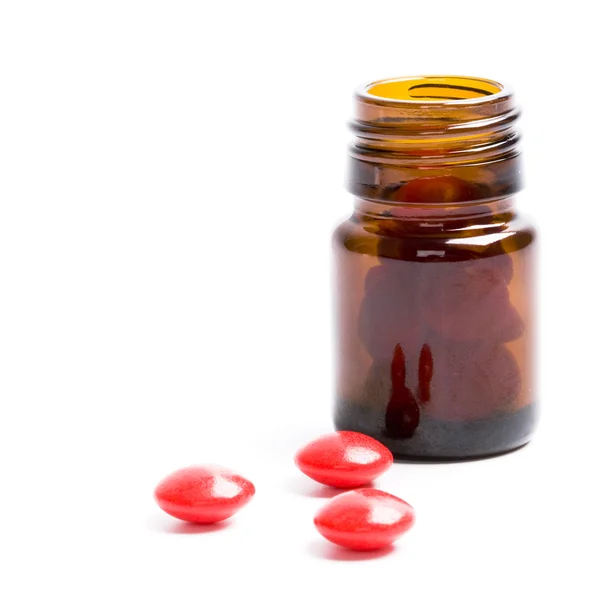 Бутылка с красными таблетками — стоковое фото