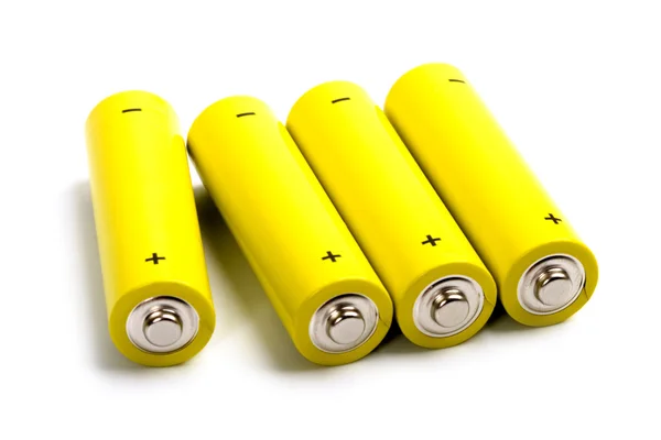 Four yellow alkaline batteries Royalty Free Stock Photos