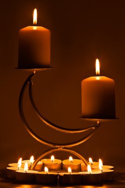 Burning candles on a support clipart