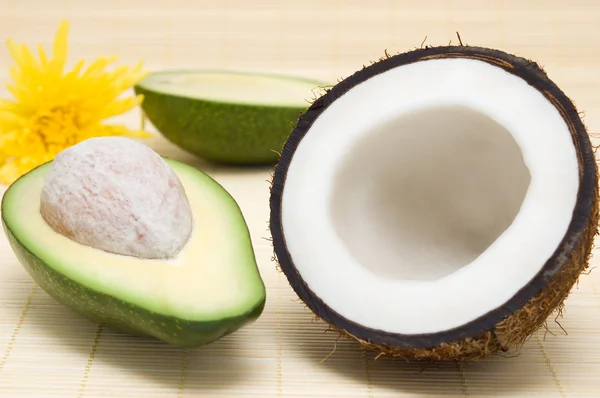 Coconut, avocado, on a rug. — Stock Photo, Image