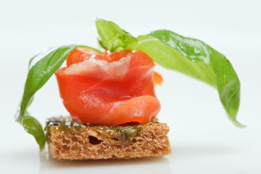 Salmon canape with basil on white clipart