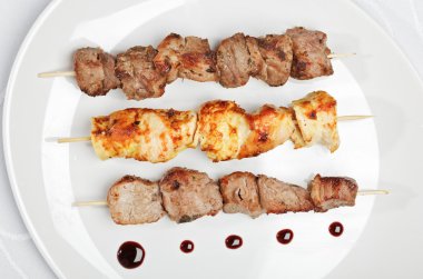 Chicken, pork and veal kebab on white clipart