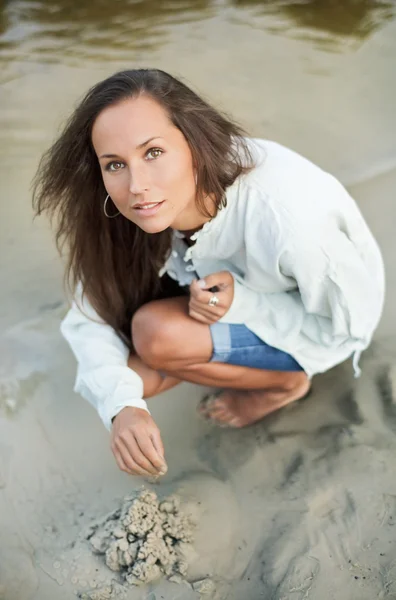 Krásná žena bilding pískový hrad — Stock fotografie