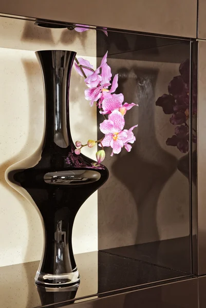 Vaso com flor de orquídea em nicho marrom — Fotografia de Stock