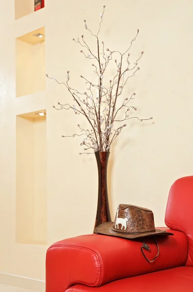 Cabecero de cuero rojo sofá, sombrero y jarrón — Foto de Stock