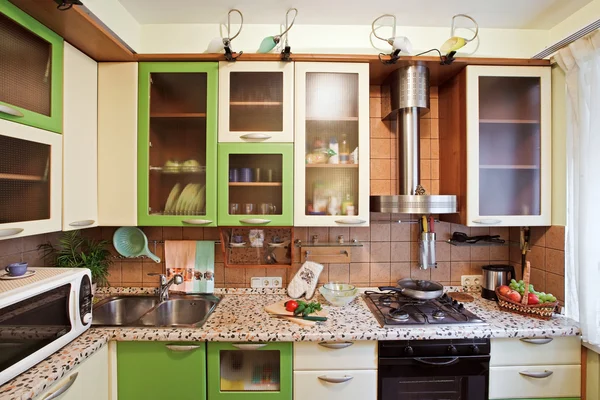 Grüne Kücheneinrichtung mit vielen Utensilien — Stockfoto
