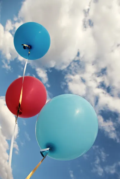 Tres globos de colores vivos en el cielo azul — Foto de Stock