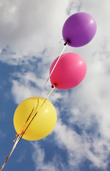 Tres globos de colores vivos en el cielo azul — Foto de Stock