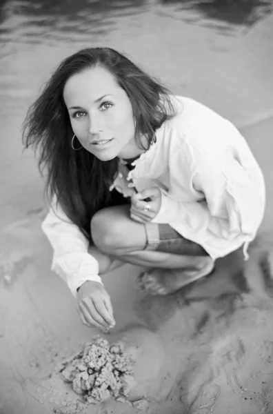 Güzel bir genç kadın kum döküm bina — Stok fotoğraf