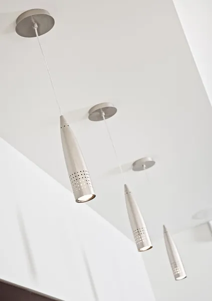 Три современных металлических лампы на белом потолке — стоковое фото