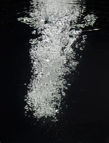 Вихревая струя воздушного пузыря в черной воде — стоковое фото