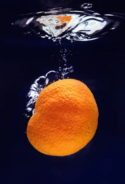 Laranja (tangerina) caindo em água azul — Fotografia de Stock