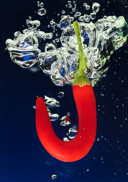 Chilli pepper falling in water — Stock Photo, Image
