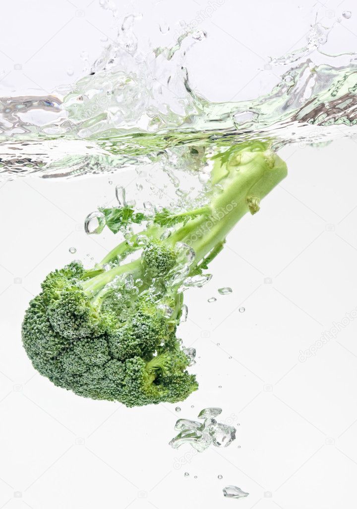 Green broccoli falling in water