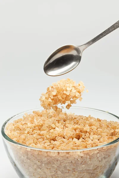 Cane sugar falling from a tea-spoon — Stock Photo, Image