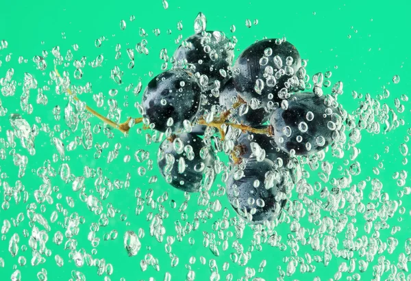 Mazzo d'uva galleggiante in acqua — Foto Stock