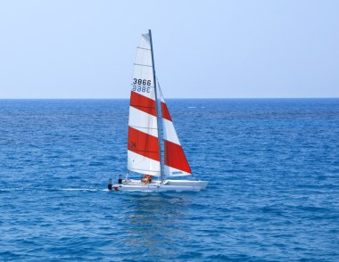 The sailing boat floats at ocean clipart