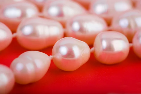 Pearls thread on the red background — Stock Photo, Image